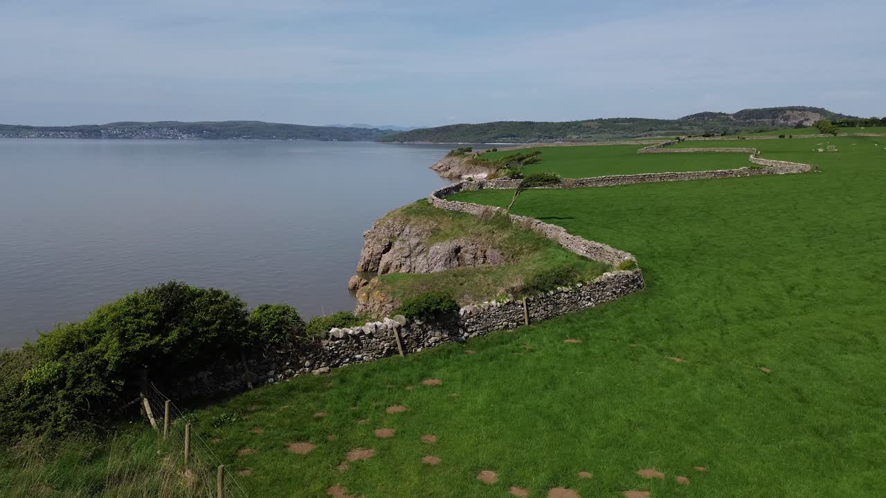 Lake district coastal farming meadow aerial view over stone wall boundary overlooking Morecambe bay