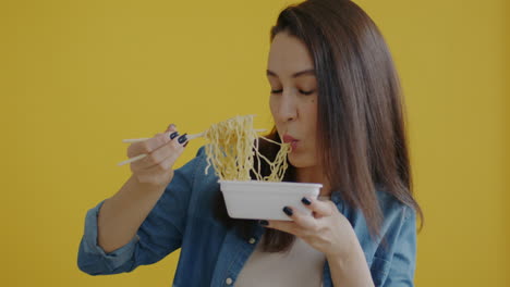 woman eating ramen with chopsticks