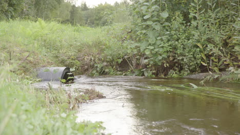 Flood-water-after-rain-downpour-enters-drainage-pipe,-extreme-weather-conditions