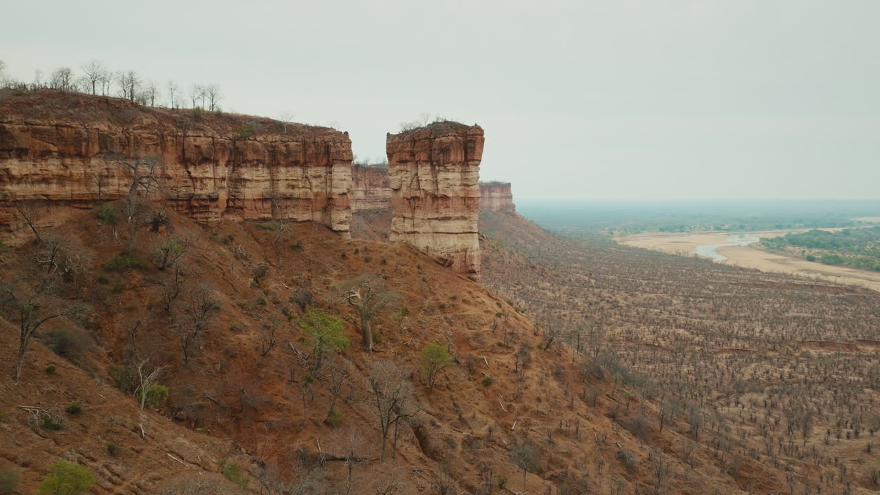 Aerial drone footage of the iconic Chilojo Cliffs in Gonarezhou National Park, Zimbabwe. Dramatic sandstone escarpment rising above the savanna part 7
