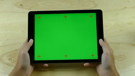 con una tableta con pantalla verde