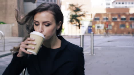 attractive business woman commuter drinking coffee walking in city of london