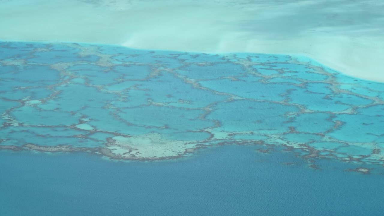 Detail view of lagoon and coral reefs in turquoise shallow water in a pacific tropical island Maupiti, French Polynesia.