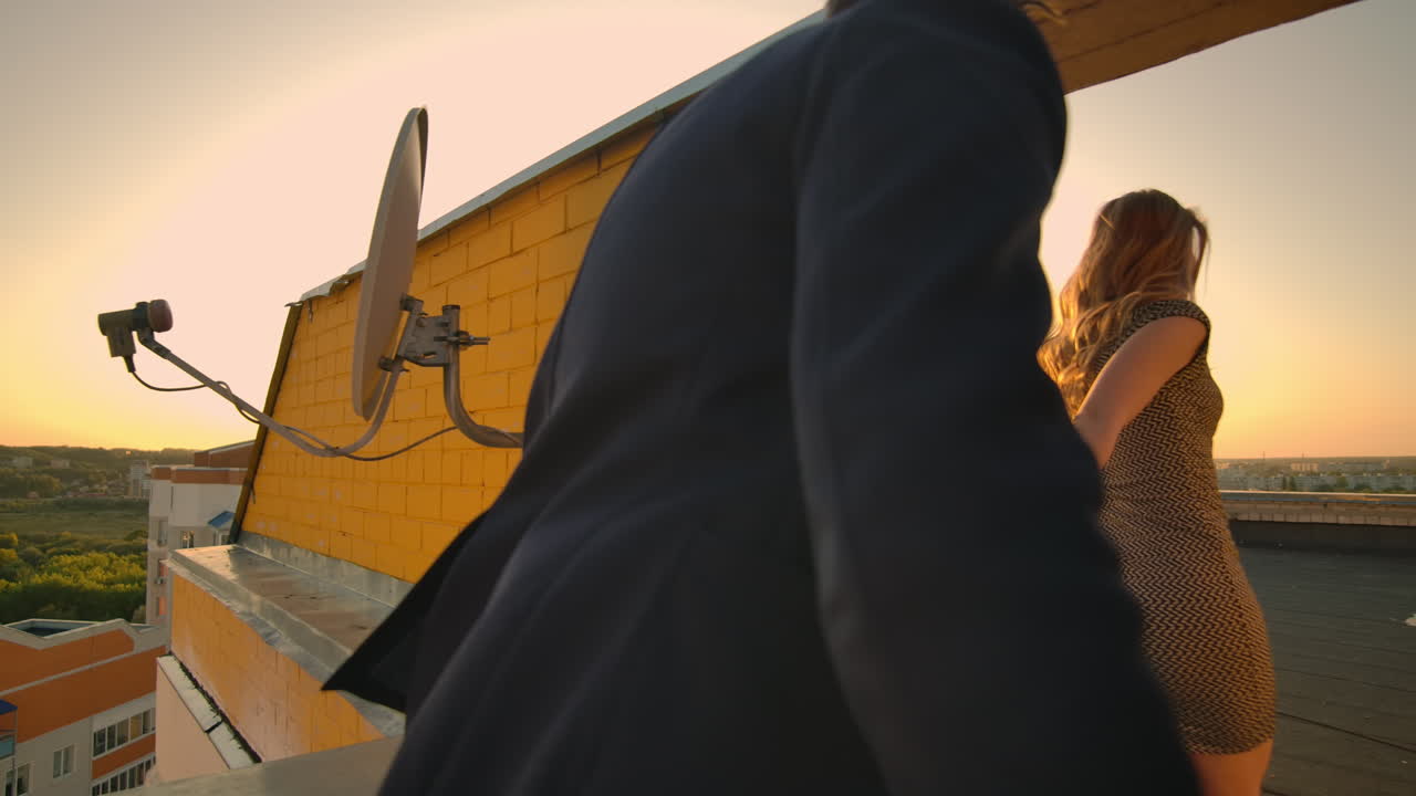 손을 잡고 는 젊은 커플, 걸어가는 여자, 남자친구, 해가 지는 건물의 지붕, 가난한 여행 개념, 무관심한 자유로운 연인, 지붕에서 웃고 미소 짓는.