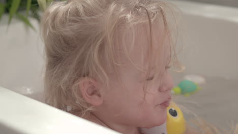 little girl playing with toys in the bath