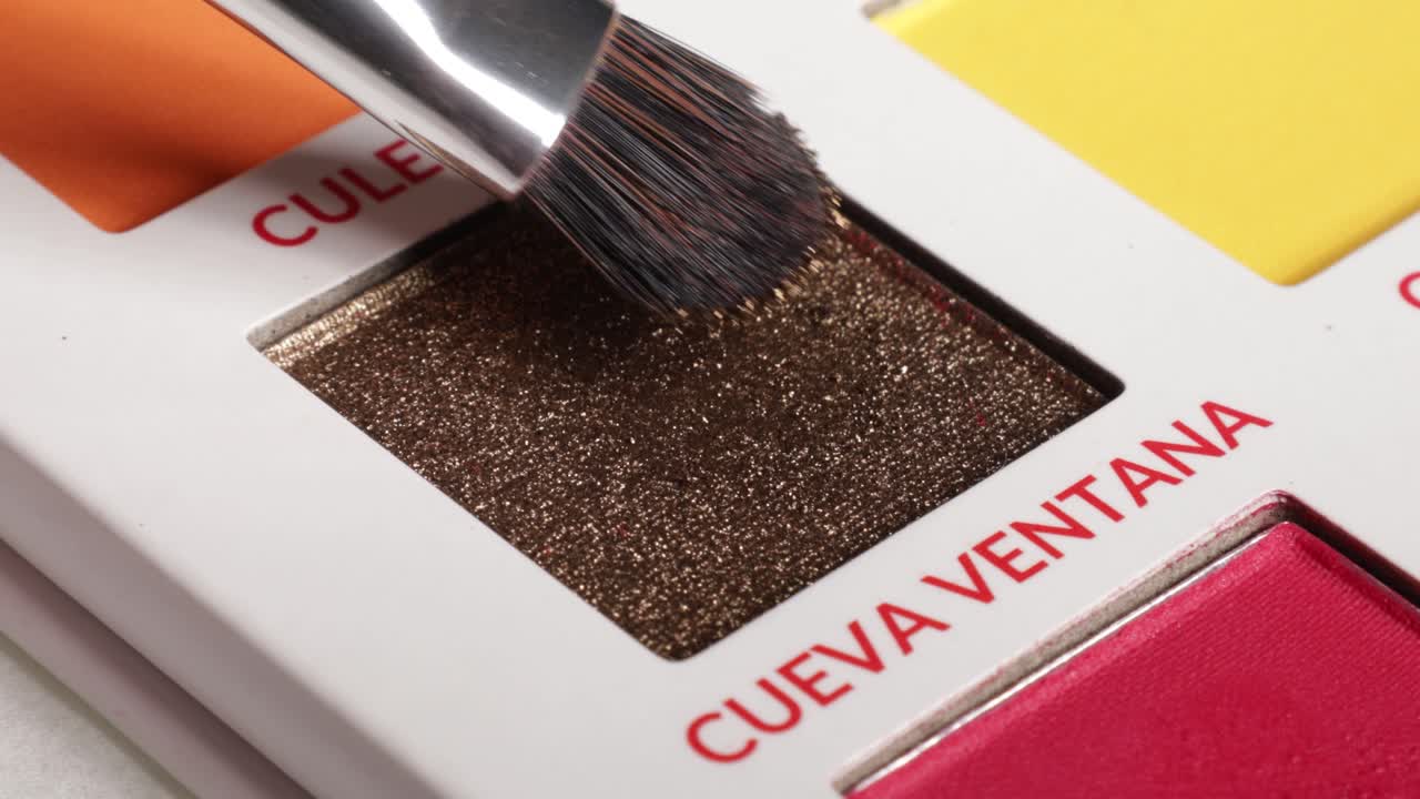 Shot of brush using eyeshadow from palette (cueva ventana).