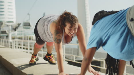 happy fat woman standing in plank with friend in public park