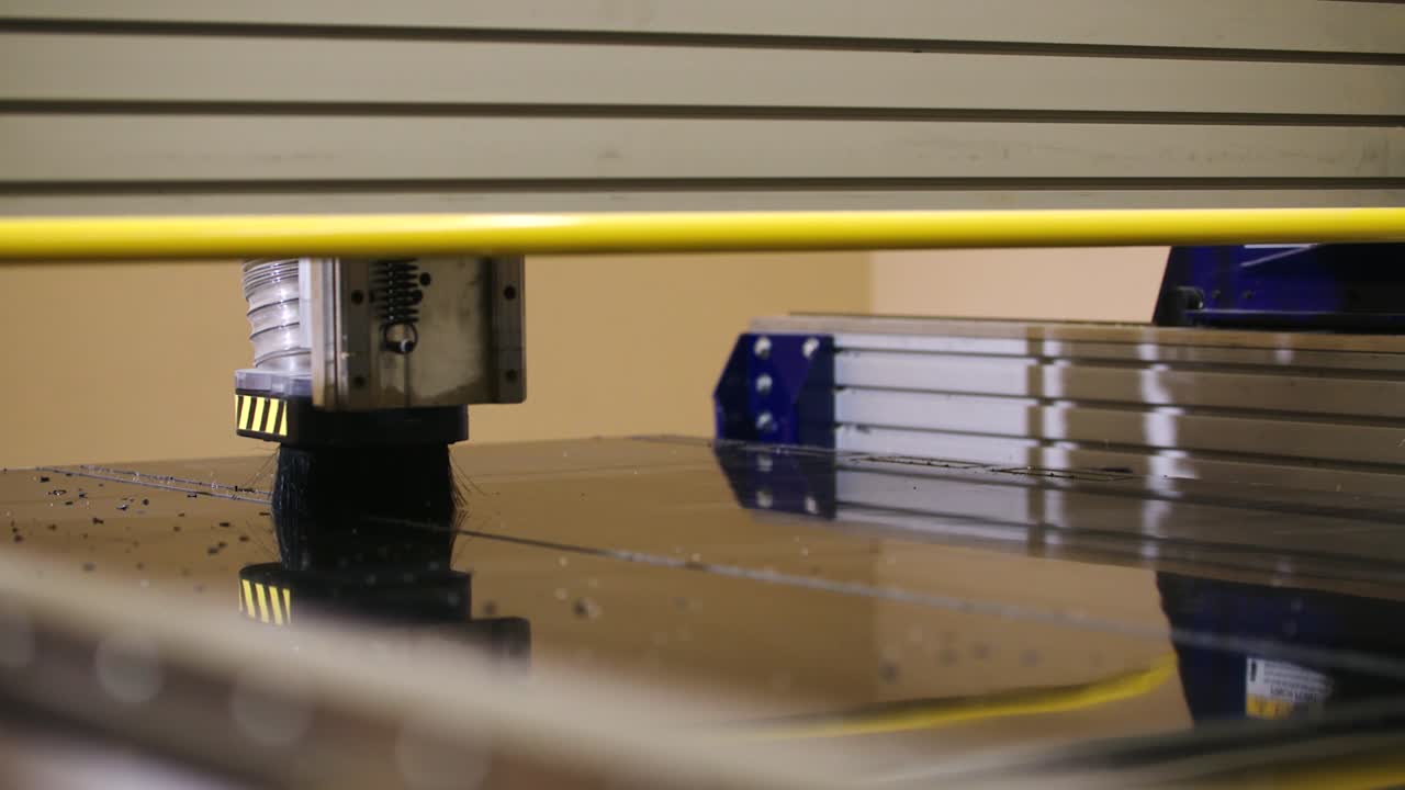 una toma deslizante de una mesa una toma deslizante de una mesa de enrutamiento cnc que corta una señalización negra en cámara lenta