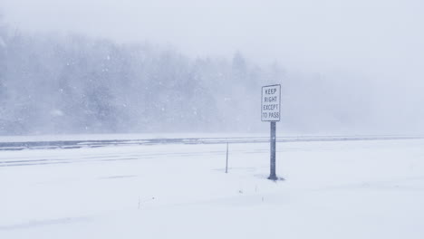 road sign and blizzard whiteout conditions on i-295 highway in freeport, maine