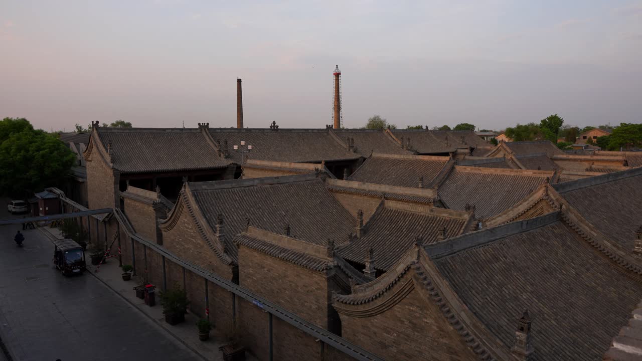 серые черепичные крыши в древнем городе пиньяо при закате с дымоходами на расстоянии, китай