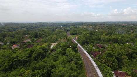 Drone-shot-following-a-train-running-on-rails-in-the-middle-of-countryside