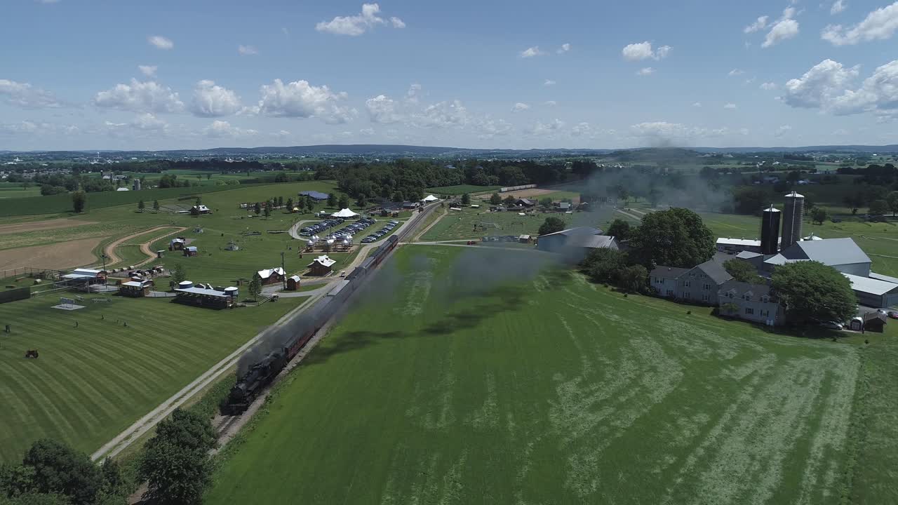 vista aérea de las tierras de cultivo y el campo con un tren de vapor antiguo que resopla en un día soleado de verano