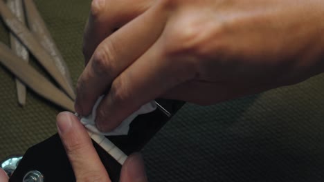 cleaning and moisturizing guitar fretboard using lemon oil cleaning conditioner in a cloth - overhead shot