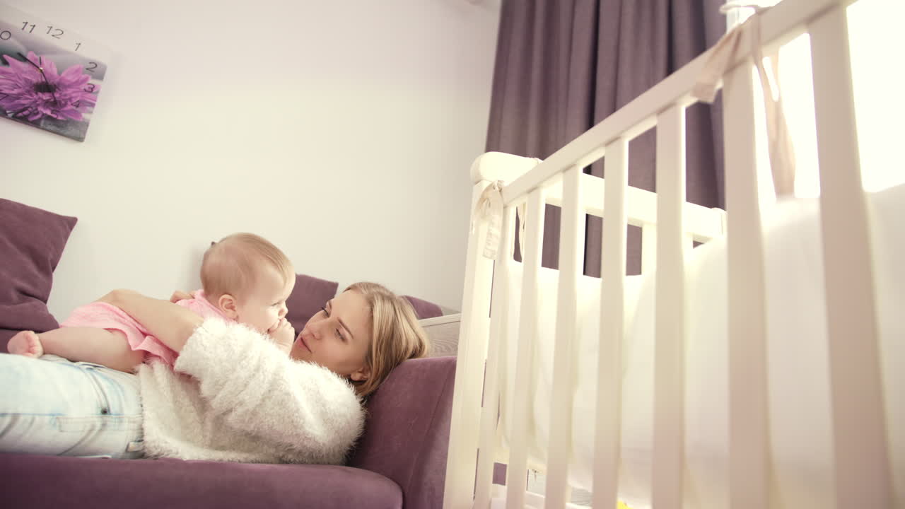 Madre con il bambino sdraiati sul divano. Stile di vita familiare. Bellissimo bambino con la madre.