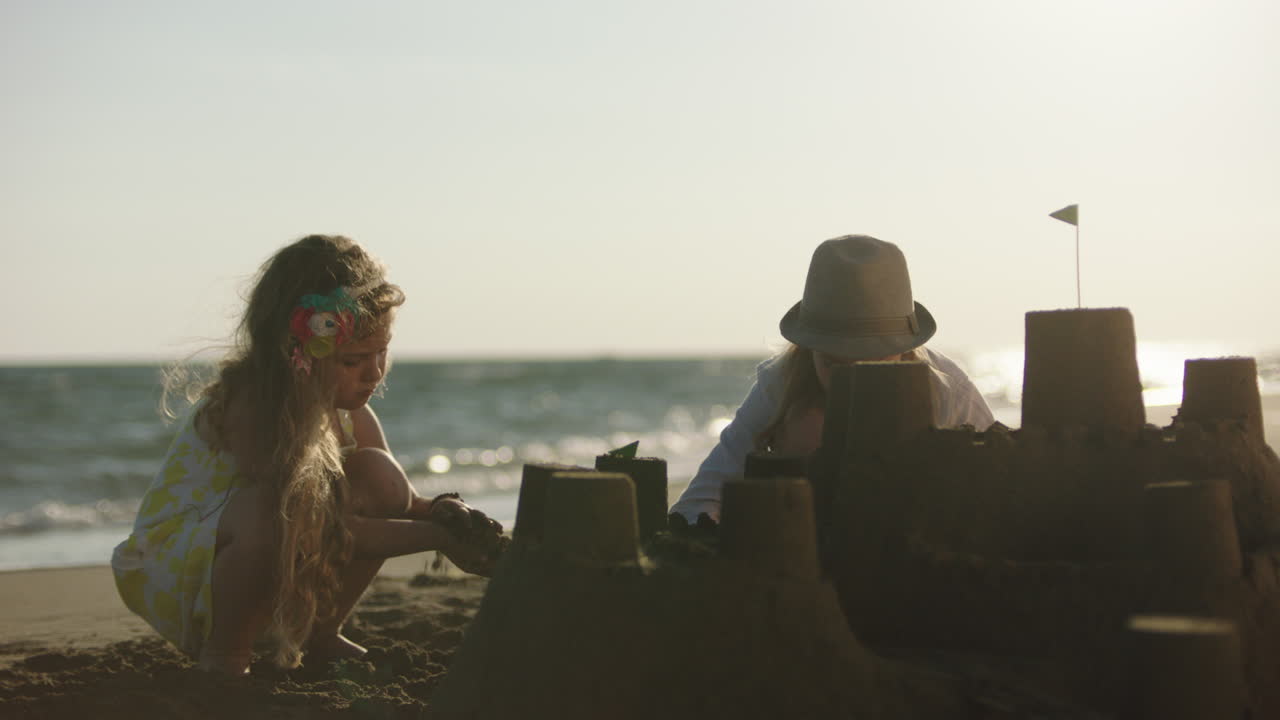 아이들이 해변에 모래 성을 짓고 있습니다.