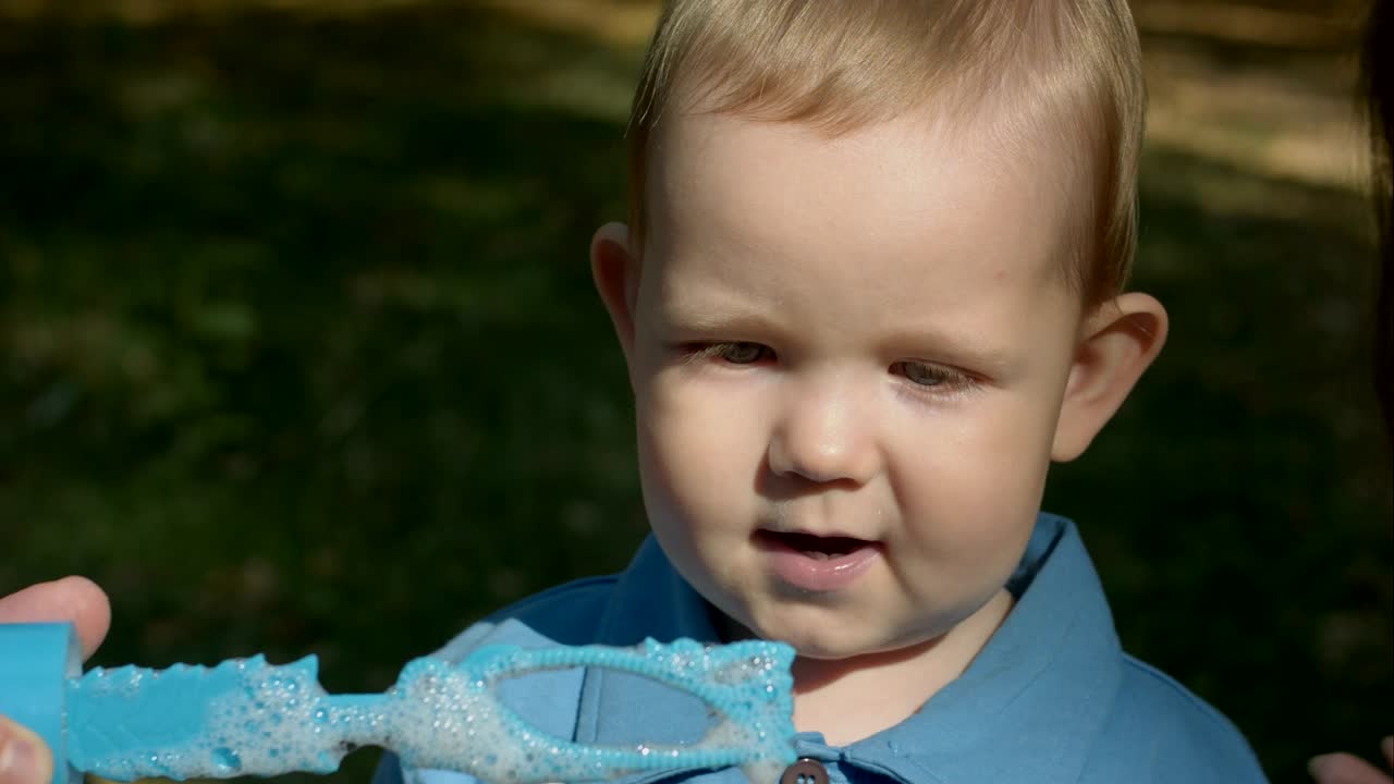 Cute boy blowing soap bubbles
