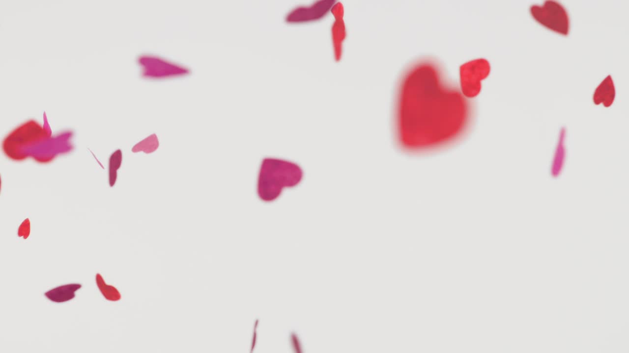 Corazones de papel encantadores - Hermosos corazones de papel sobre un fondo blanco - video vertical - cámara lenta - bucle sin fin