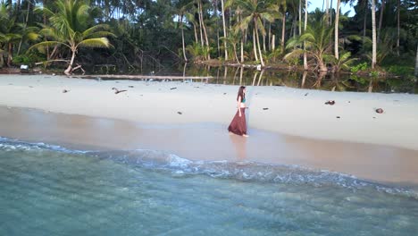 young pretty woman walking back and forth with long skirt on beach