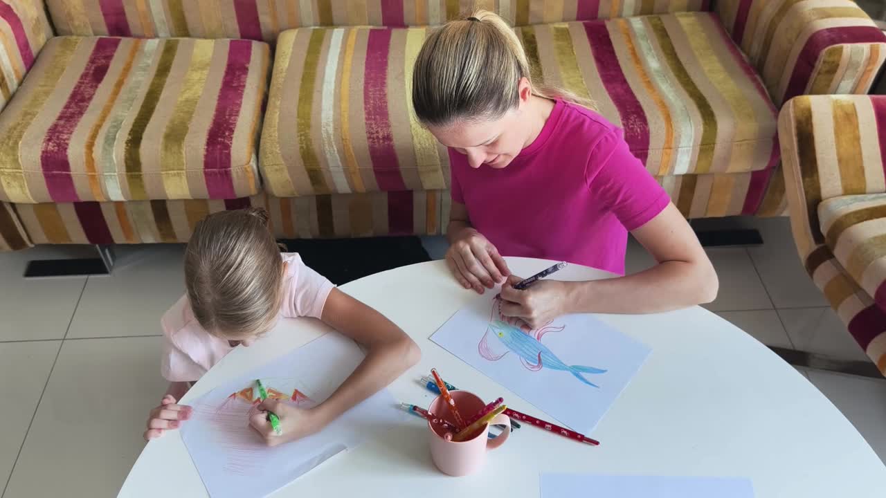 어머니와 딸이 함께 그림을 그리고 있습니다.