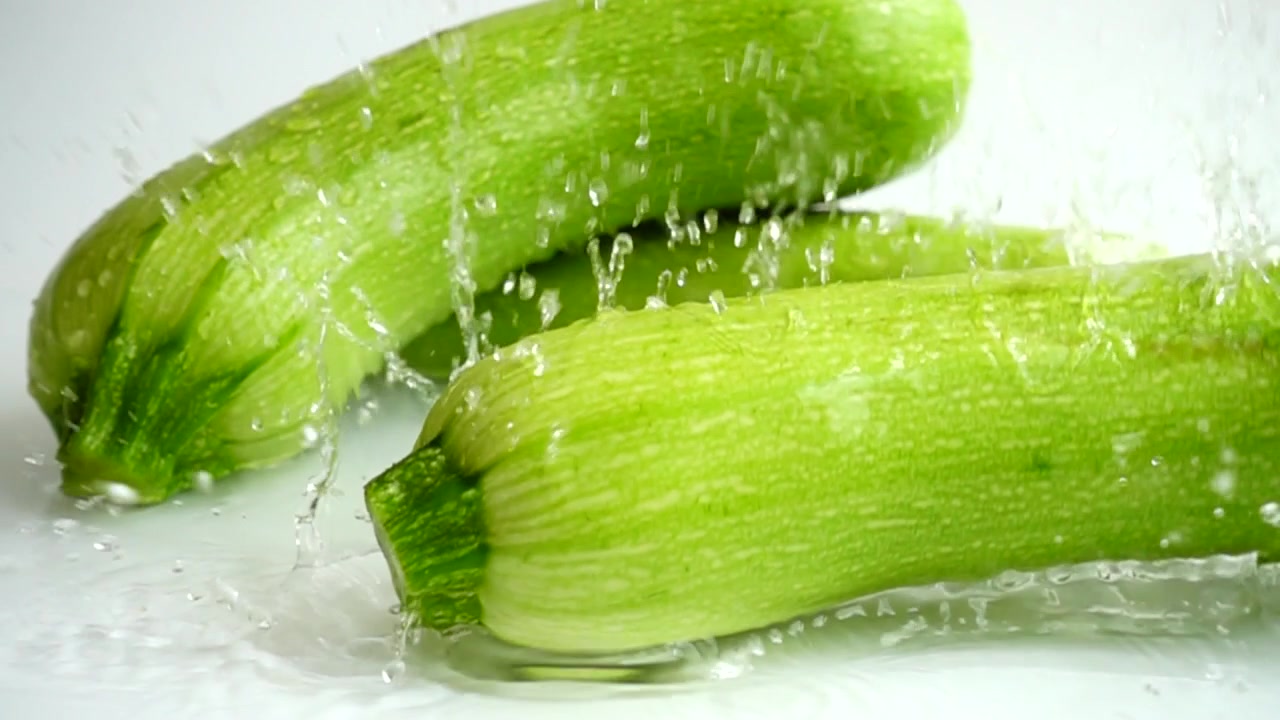 Zucchina e spruzzo d'acqua. Movimento lento
