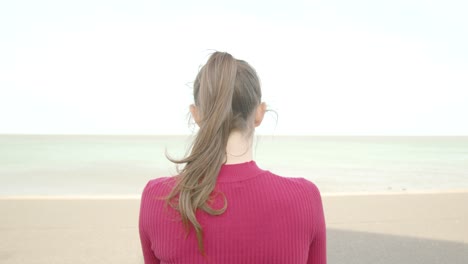 Young-woman-sits-down-turns-her-phone-off-and-looks-out-to-sea