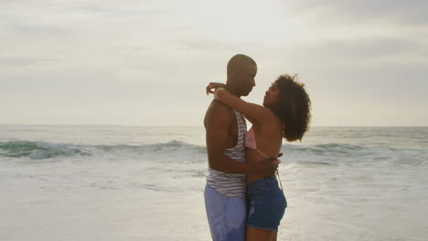 vista lateral de una pareja afroamericana bailando juntos en la playa 4k
