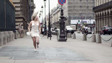 woman in white dress walking through parisian streets