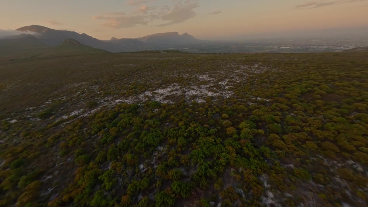 Drone che vola giù da una montagna con la Table Mountain sullo sfondo