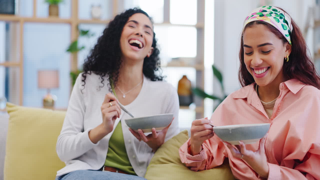 レズビアンカップルが朝食と一緒にソファーに