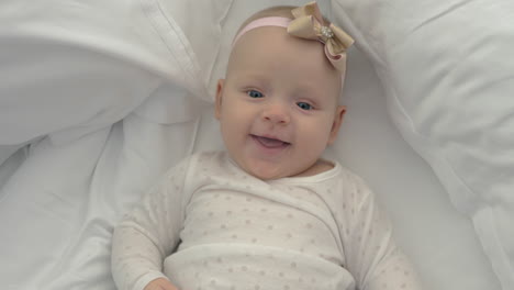 smiling blue-eyed baby girl with bow