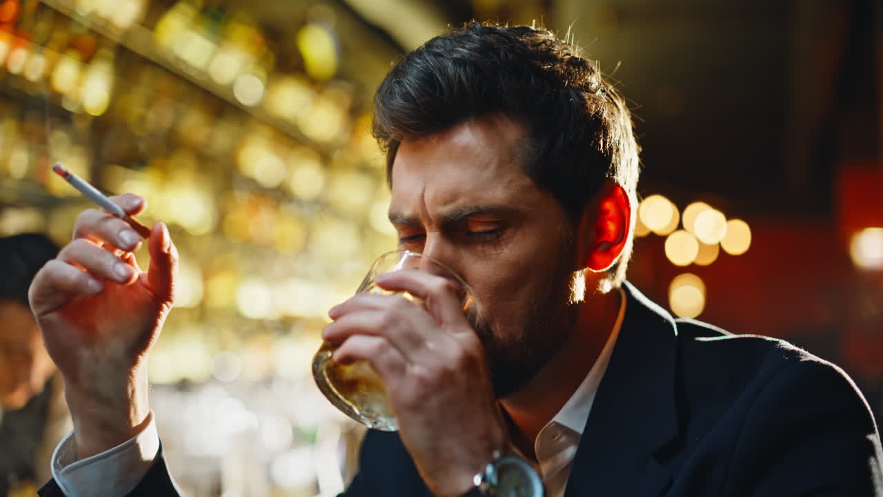 Tired businessman smoking cigarette in quiet bar lounge focus view closeup