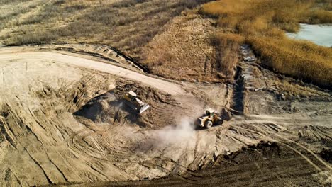 Eine-Große-Baustelle-Mit-Bulldozern,-Die-Schmutz-Bewegen-Und-Staub-Verursachen-–-Luftaufnahme