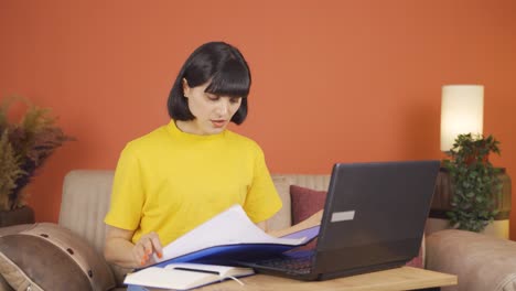 노트북에서 일하는 여자가 분노로 파일을 던집니다.