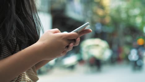 Handheld-view-of-woman’s-hands-sending-text-message