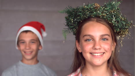 hermanos con guirnaldas y sombreros para celebrar la navidad