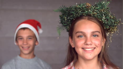 siblings wearing garland and hat to celebrate christmas