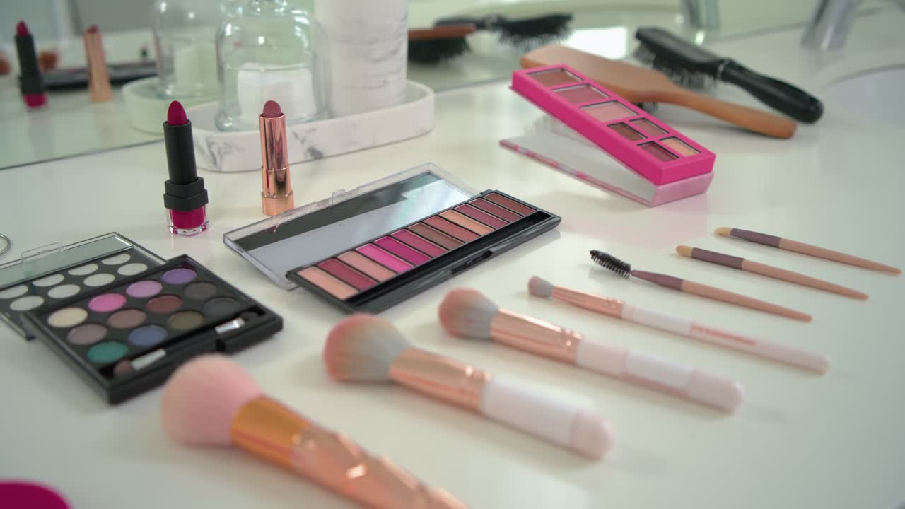 Camera panning right and forward is revealing makeup brushes and palettes to showcase vanity layout