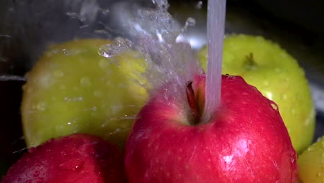 manzana siendo lavada con agua salpicada close-up slomotion