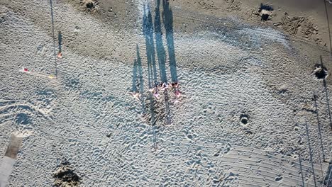 top view of some people on a sandy beach with shadows, genoa, italy. aerial drone shot