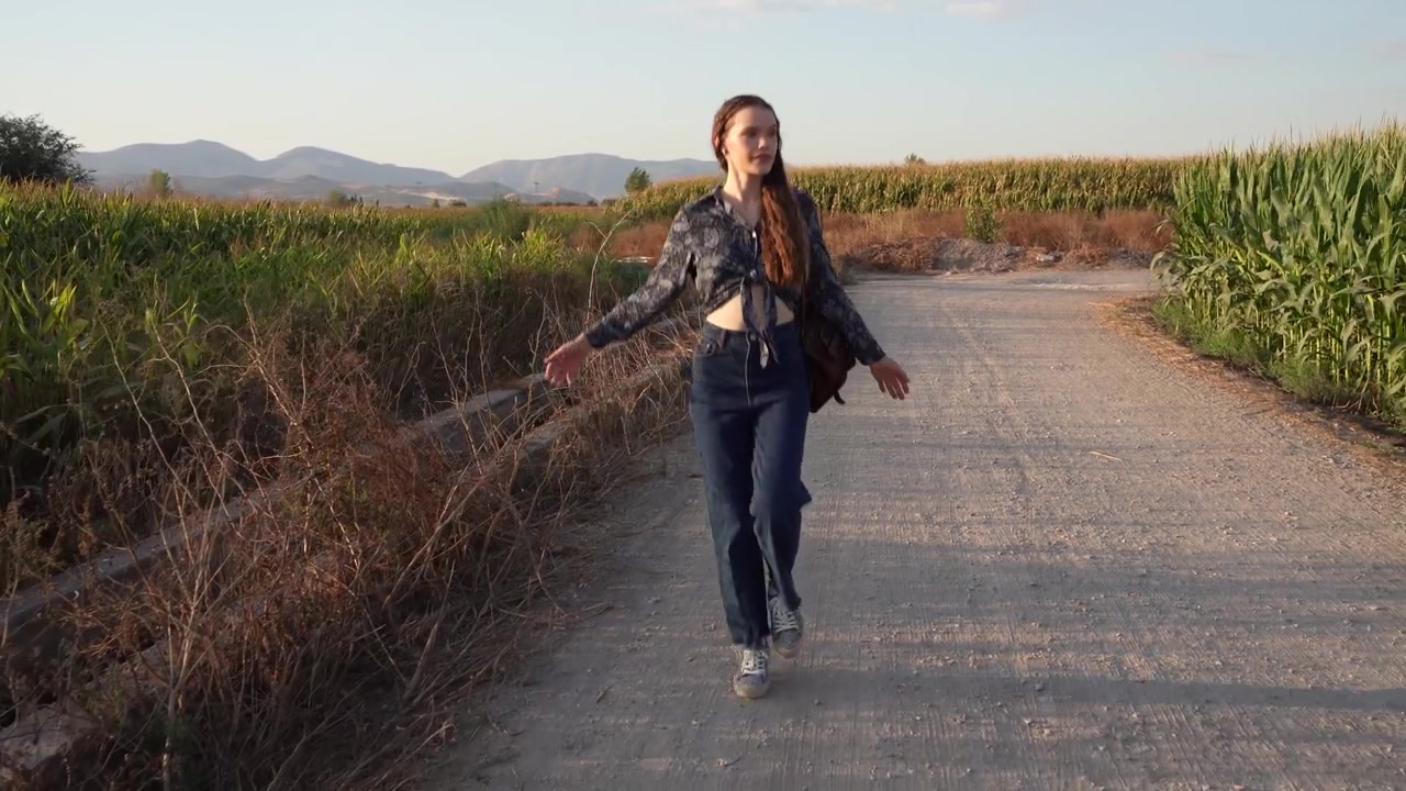 Una giovane donna che passeggia attraverso un bellissimo paesaggio scenografico all'ora del crepuscolo.