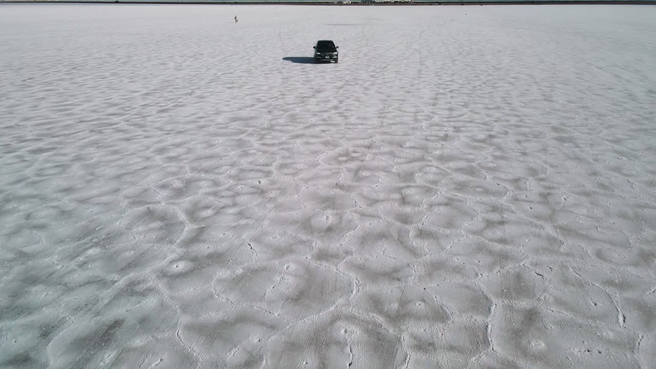 el video cinematográfico de un dron rastreando un automóvil desde el frente en un control remoto es como un desierto a alta velocidad, salinas de bonnesville, utah, clip aéreo de ee. uu. 4k