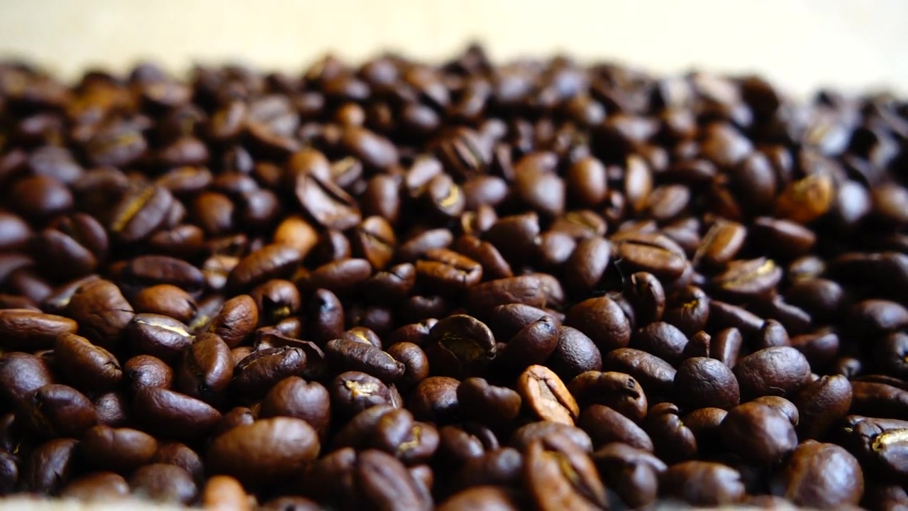 Chicchi di caffè che cadono sul sacco. Al rallentatore.