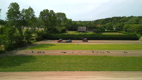 fly away shot of tractors working rows in a field