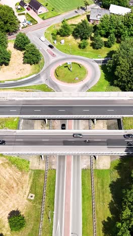 aerial view of a multi-level highway system with roundabout and traffic