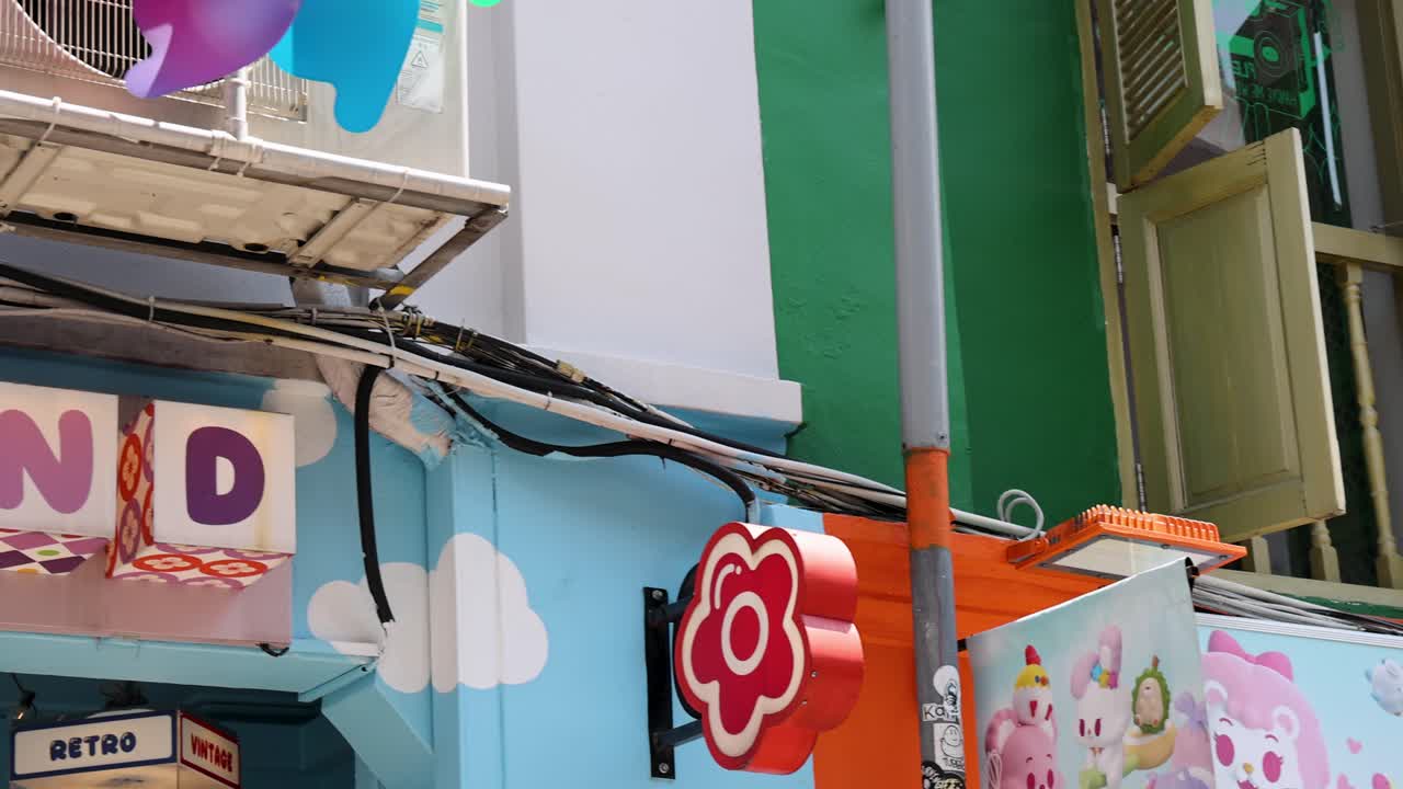 Camera pans along vibrant shopfronts, open windows, and spinning pinwheels in bright daylight