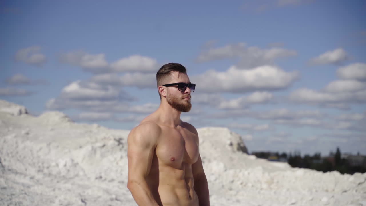 Attractive young muscle man outdoors. Muscular athletic bodybuilder man posing outdoor