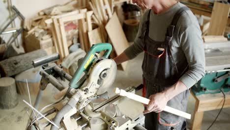 high angle view of skilled furniture maker working on table leg. man making decorative cuts in piece of wood