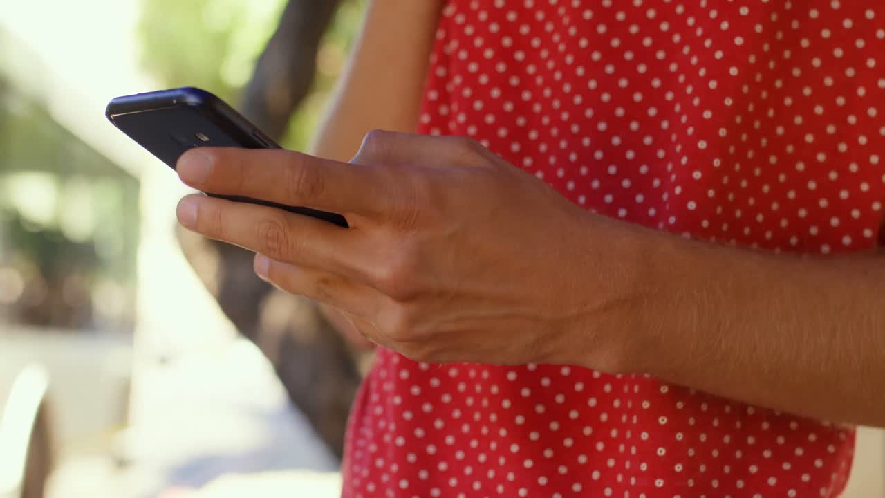 Pendolare uomo che usa il cellulare alla fermata dell'autobus 4k