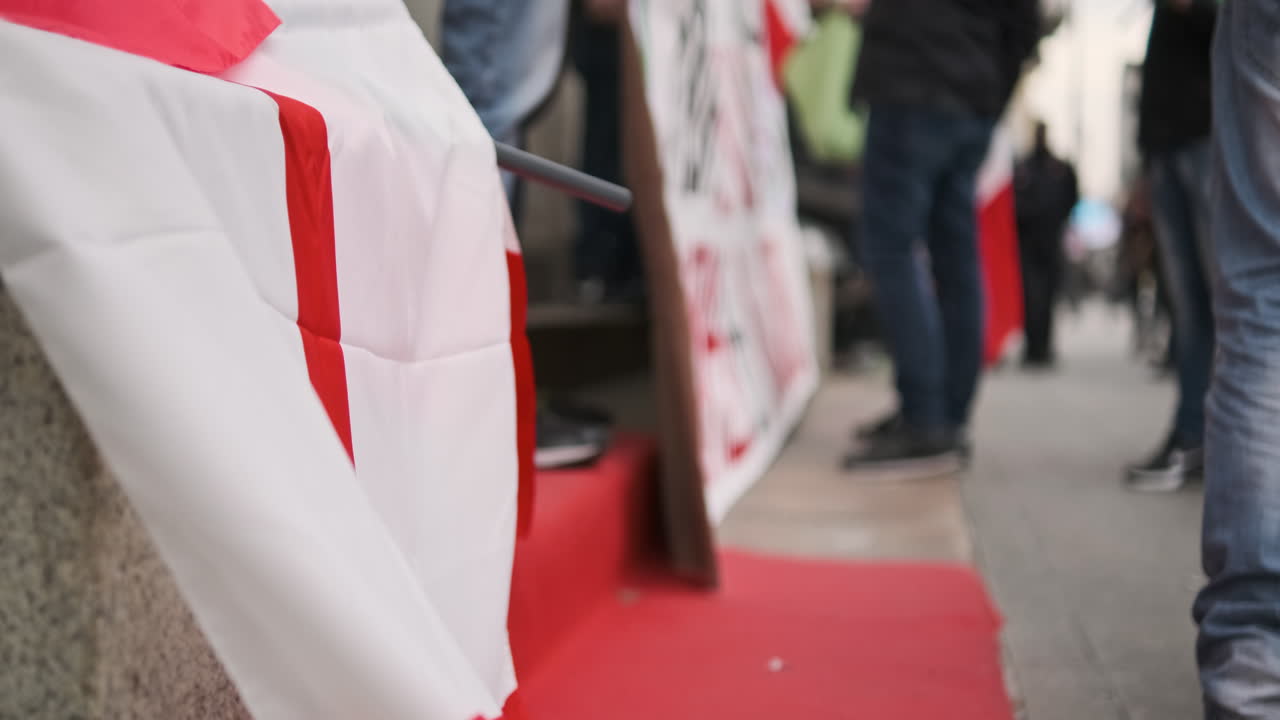 enfoque en la vista de la bandera italiana apoyada en un escalón durante la protesta contra el grupo gubernamental de personas con pancartas en el fondo