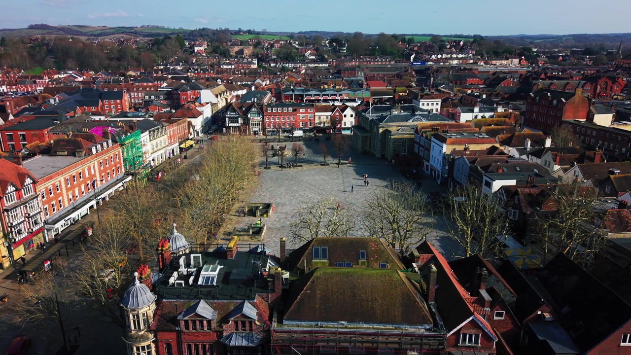 Wide aerial view over Salisbury Market Place showing the historic public square, Guildhall and surrounding city centre buildings in Wiltshire England